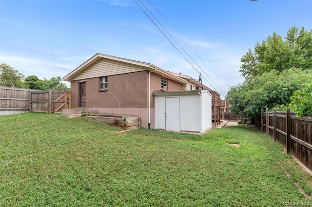 8485 W 44th Ave, Wheat Ridge, CO 80033 - back of property featuring brick siding, a fenced backyard, a storage unit, and a vegetable garden