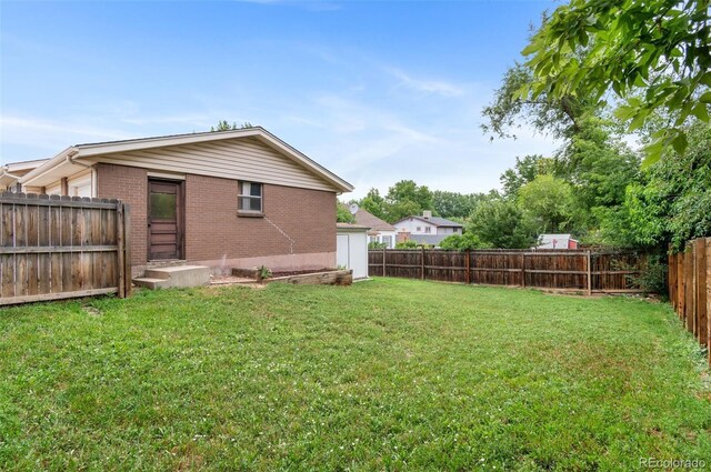 8485 W 44th Ave, Wheat Ridge, CO 80033 - rear view of house featuring brick siding and a fenced backyard