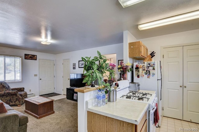 kitchen featuring light colored carpet, a baseboard radiator, and white gas stove