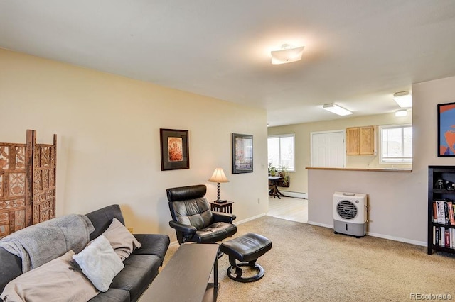 carpeted living room featuring a baseboard heating unit and a wealth of natural light
