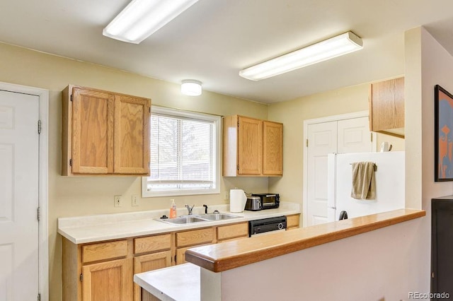 kitchen with white refrigerator, light brown cabinetry, dishwasher, and sink