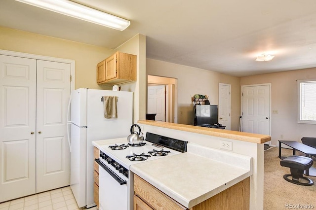 kitchen featuring white appliances, kitchen peninsula, and light brown cabinets