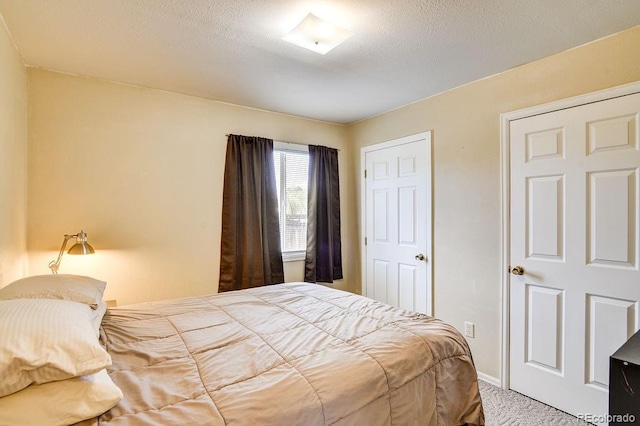 carpeted bedroom featuring a textured ceiling