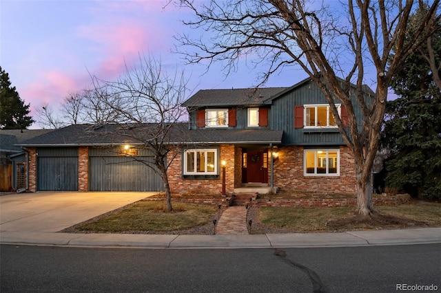 traditional home with concrete driveway, an attached garage, and brick siding