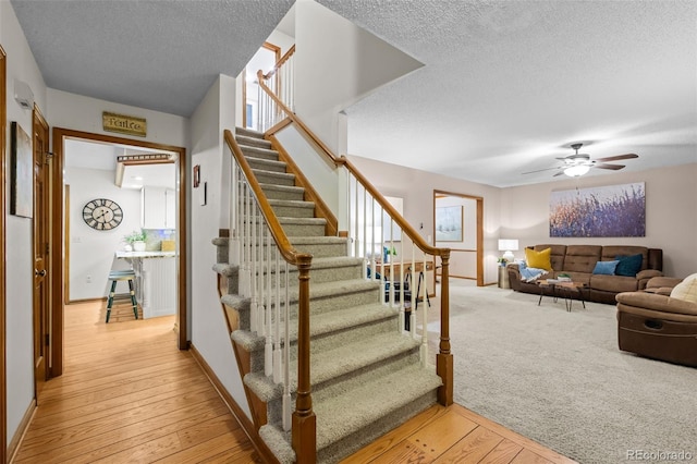 2090 S Gray Dr, Lakewood, CO 80227 - stairway featuring baseboards, carpet, hardwood / wood-style flooring, a textured ceiling, and a ceiling fan