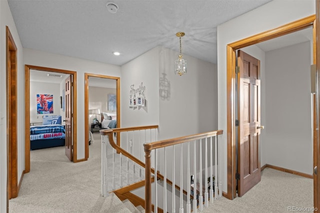 2090 S Gray Dr, Lakewood, CO 80227 - hallway with visible vents, baseboards, carpet floors, an upstairs landing, and a notable chandelier