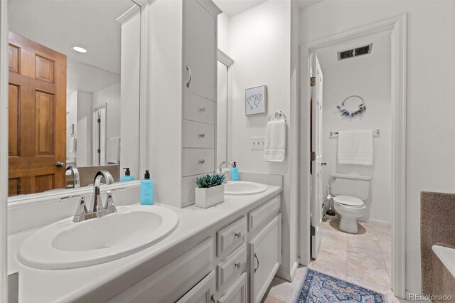 2090 S Gray Dr, Lakewood, CO 80227 - full bath featuring visible vents, toilet, a sink, tile patterned flooring, and double vanity