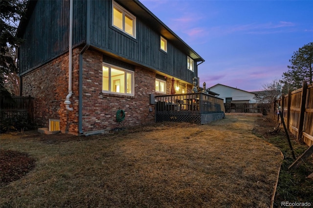 2090 S Gray Dr, Lakewood, CO 80227 - rear view of property featuring a wooden deck, a yard, a fenced backyard, brick siding, and board and batten siding