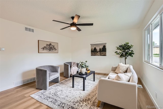 14317 Olmsted Dr, Denver, CO 80239 - living room featuring wood finished floors, a ceiling fan, a textured ceiling, and baseboards