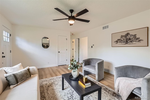 14317 Olmsted Dr, Denver, CO 80239 - living area with light wood finished floors, ceiling fan, baseboards, and a textured ceiling