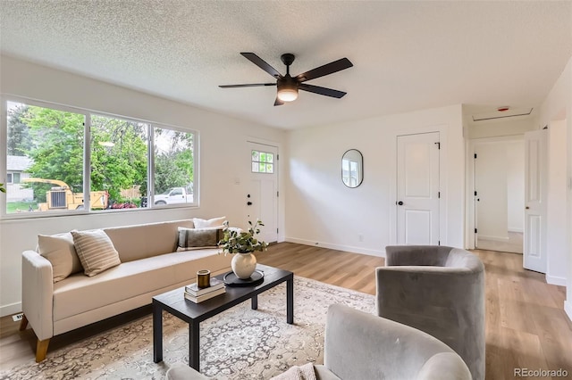 14317 Olmsted Dr, Denver, CO 80239 - living area with light wood finished floors, ceiling fan, baseboards, and a textured ceiling