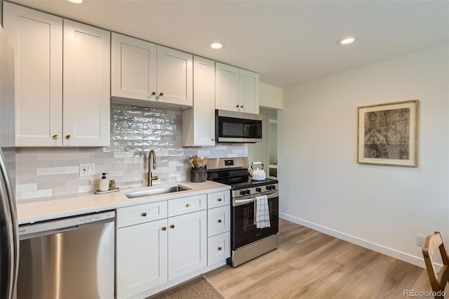 14317 Olmsted Dr, Denver, CO 80239 - kitchen featuring stainless steel appliances, a sink, baseboards, light countertops, and tasteful backsplash