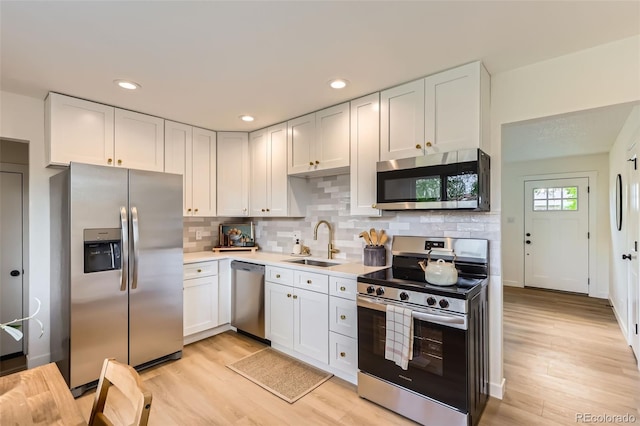 14317 Olmsted Dr, Denver, CO 80239 - kitchen with stainless steel appliances, a sink, light countertops, tasteful backsplash, and light wood-style floors