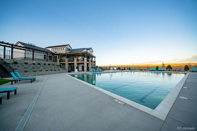 pool at dusk featuring a patio area