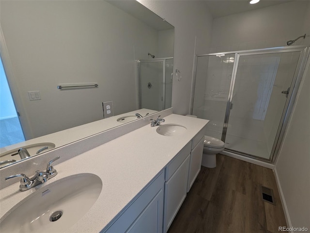 bathroom featuring vanity, wood-type flooring, an enclosed shower, and toilet