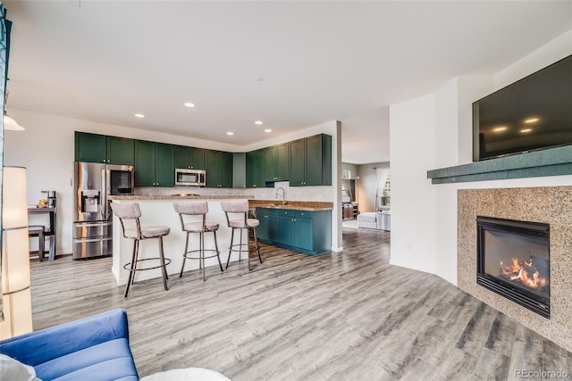 22765 E Ottawa Pl, Aurora, CO 80016 - living room featuring light wood-style floors, recessed lighting, and a glass covered fireplace