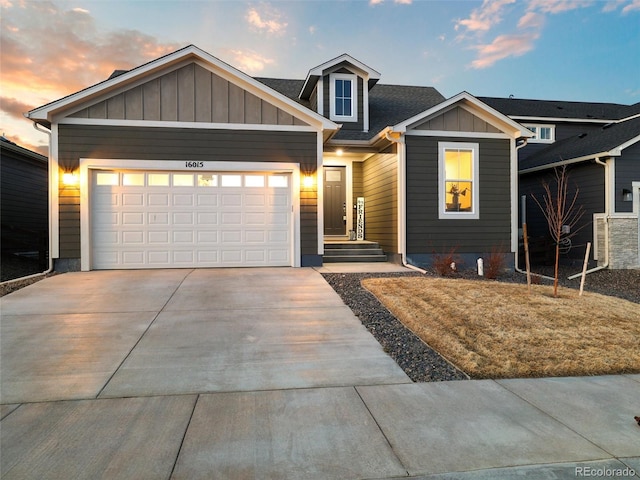 view of front of house featuring a garage, concrete driveway, roof with shingles, and board and batten siding