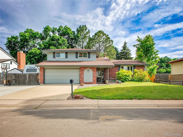 4720 W Stanford Ave, Denver, CO 80236 - view of front facade featuring driveway, a garage, and brick siding