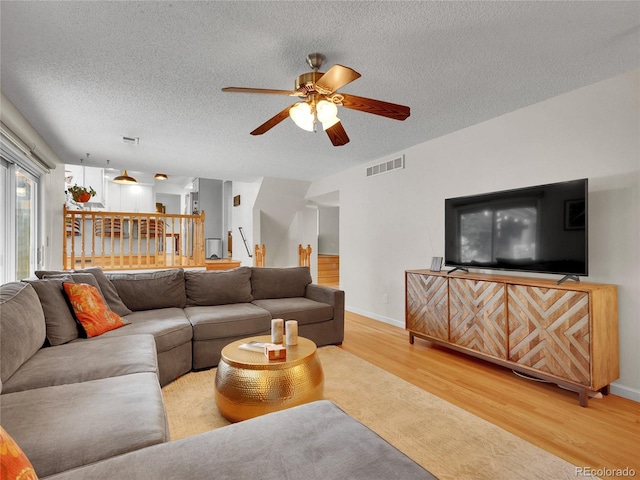 4720 W Stanford Ave, Denver, CO 80236 - living area with light wood-style flooring, a ceiling fan, and a textured ceiling