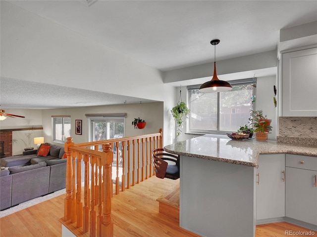 4720 W Stanford Ave, Denver, CO 80236 - kitchen featuring light wood-style flooring, plenty of natural light, light stone counters, and ceiling fan
