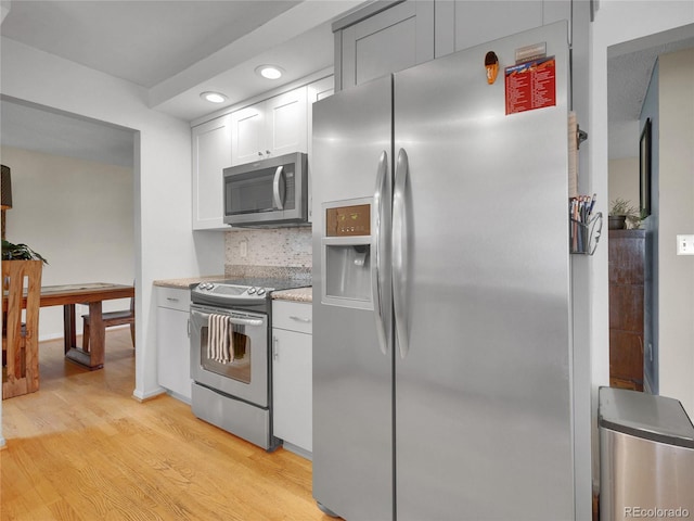 4720 W Stanford Ave, Denver, CO 80236 - kitchen featuring appliances with stainless steel finishes, light wood finished floors, white cabinets, recessed lighting, and backsplash