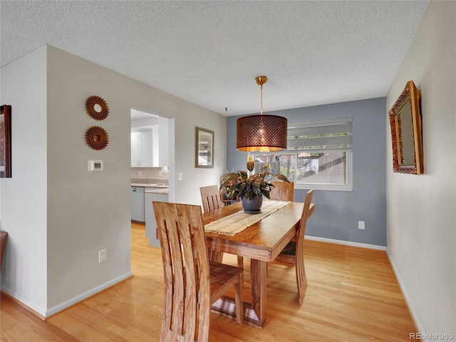 4720 W Stanford Ave, Denver, CO 80236 - dining area featuring light wood-style flooring and a textured ceiling