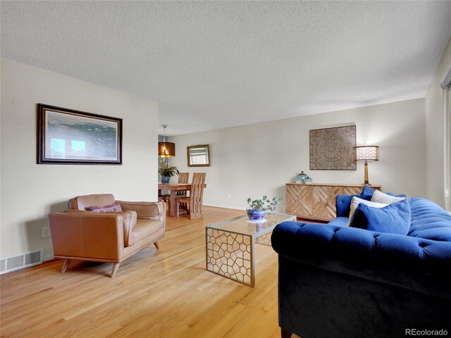 4720 W Stanford Ave, Denver, CO 80236 - living room featuring light wood-style flooring and a textured ceiling
