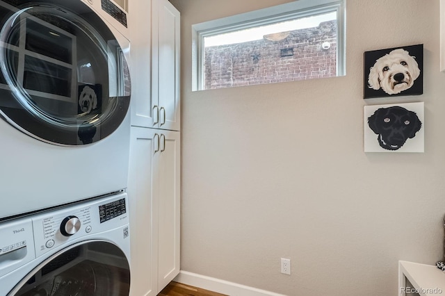 2436 W Argyle Pl, Denver, CO 80211 - laundry room with stacked washer / drying machine, cabinet space, wood finished floors, and baseboards