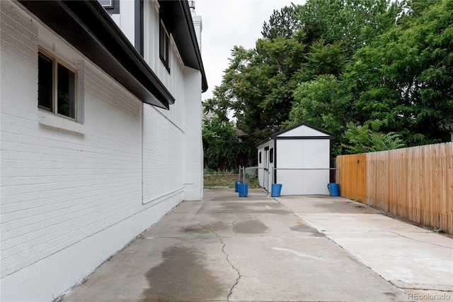 8249 Zephyr St, Arvada, CO 80005 - view of side of home with a patio area, a storage unit, and board and batten siding