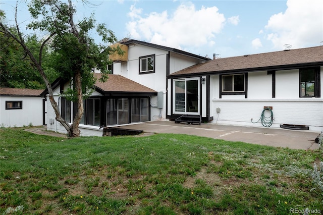 8249 Zephyr St, Arvada, CO 80005 - rear view of house featuring a sunroom, a patio, a lawn, and a shingled roof