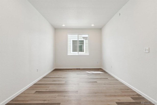 spare room with recessed lighting, baseboards, and light wood-style floors