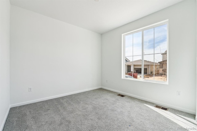 carpeted empty room with visible vents and baseboards