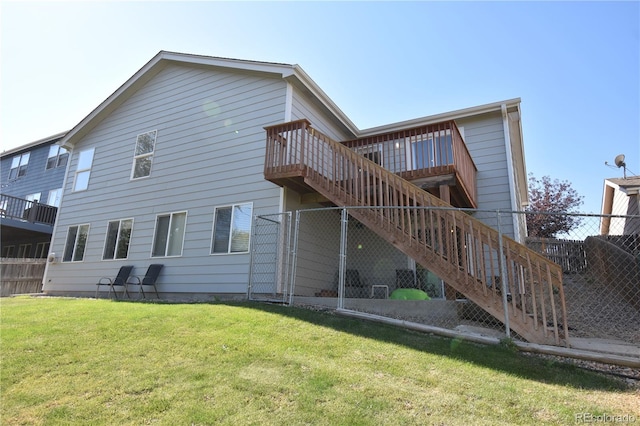 back of property featuring a wooden deck and a lawn