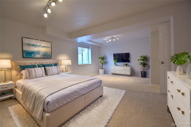 bedroom featuring light carpet and rail lighting