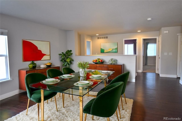 dining area featuring a healthy amount of sunlight and dark wood-type flooring