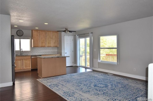 kitchen featuring dark hardwood / wood-style flooring, a healthy amount of sunlight, stainless steel appliances, and a kitchen island