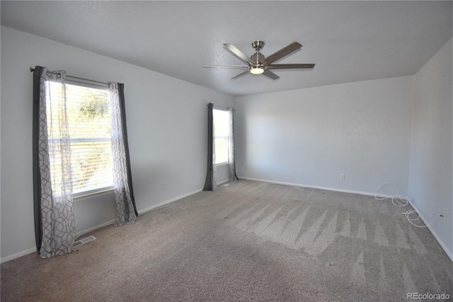 carpeted spare room featuring ceiling fan