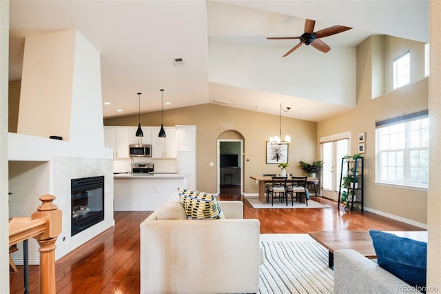 7777 E 23rd Ave Unit 1202, Denver, CO 80238 - living area featuring wood-type flooring, high vaulted ceiling, a fireplace, a ceiling fan, and a chandelier