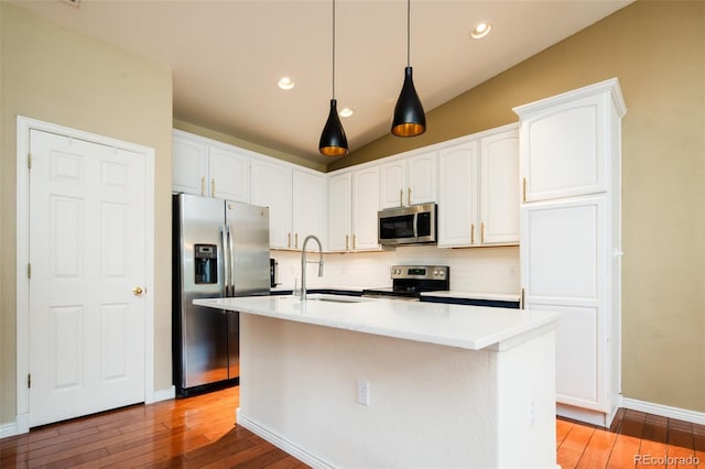7777 E 23rd Ave Unit 1202, Denver, CO 80238 - kitchen featuring appliances with stainless steel finishes, light wood-style flooring, tasteful backsplash, white cabinets, and vaulted ceiling