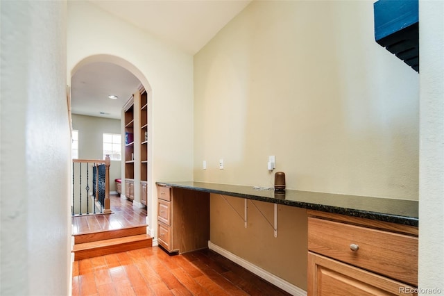 7777 E 23rd Ave Unit 1202, Denver, CO 80238 - bar area featuring light wood-style flooring, arched walkways, and built in desk