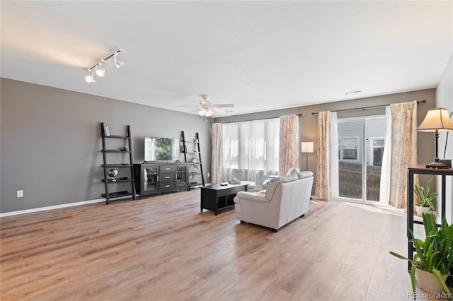 living area featuring light wood-style flooring, baseboards, visible vents, ceiling fan, and rail lighting