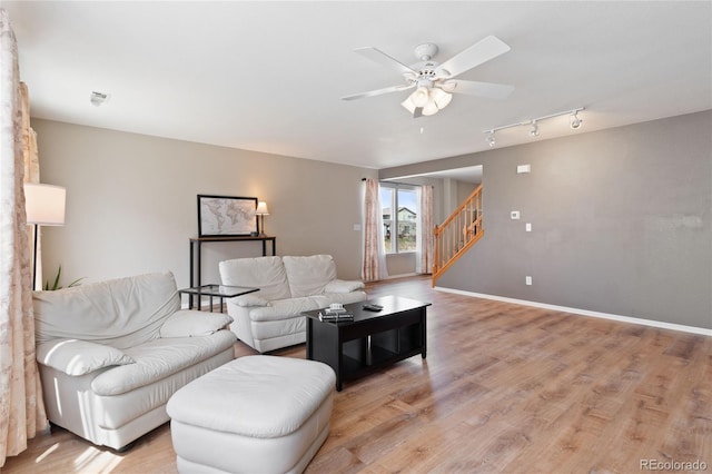 living area featuring track lighting, light wood-style floors, stairway, and a ceiling fan