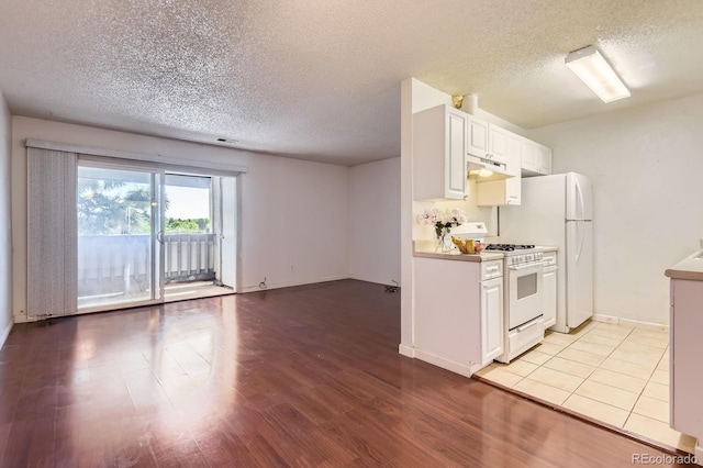 10762 E Exposition Ave Unit 336, Aurora, CO 80012 - kitchen with white range with gas cooktop, under cabinet range hood, a textured ceiling, light wood finished floors, and white cabinets