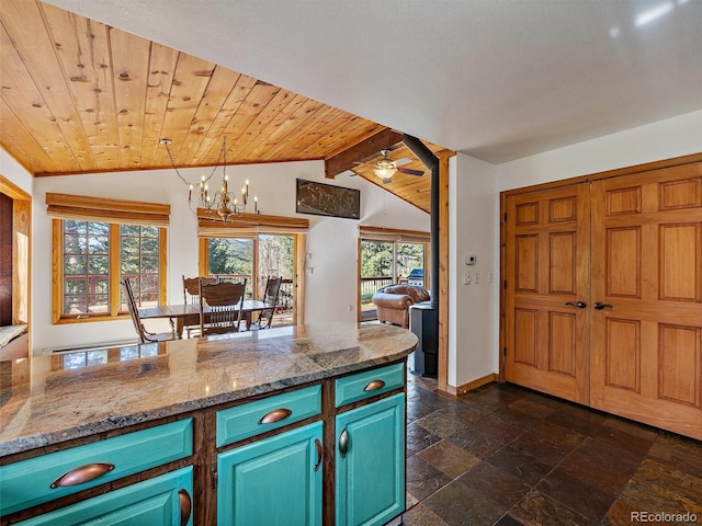 7754 Swaps Trl, Evergreen, CO 80439 - kitchen featuring stone tile floors, a chandelier, baseboards, decorative light fixtures, and blue cabinetry