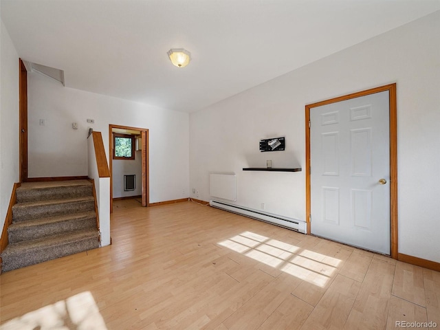 7754 Swaps Trl, Evergreen, CO 80439 - unfurnished living room featuring baseboard heating, light wood-style flooring, baseboards, and stairs