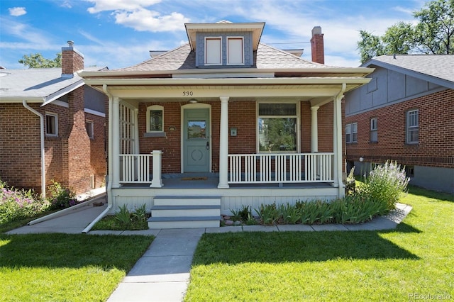 bungalow with a porch and a front lawn