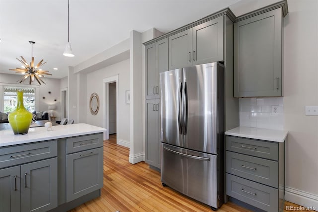 kitchen featuring tasteful backsplash, stainless steel fridge, and gray cabinetry