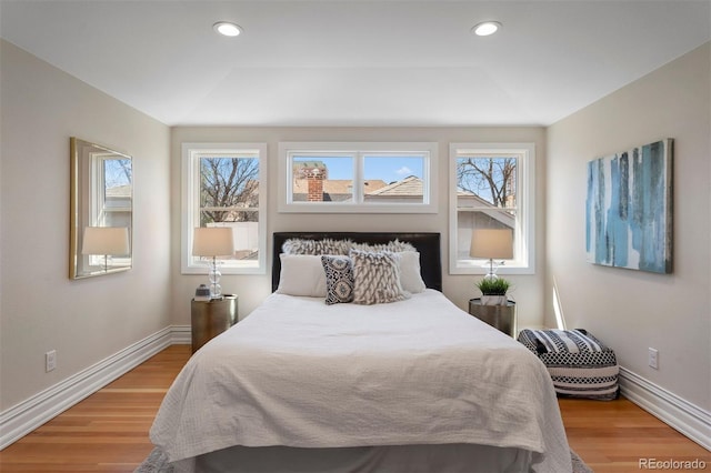 bedroom with hardwood / wood-style flooring and a tray ceiling