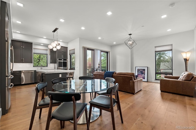 dining space with light wood-type flooring and recessed lighting