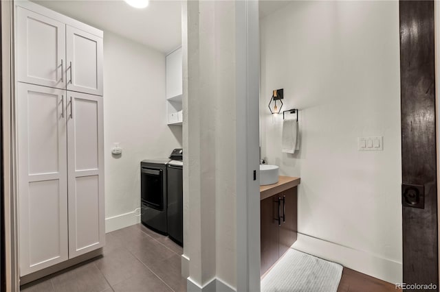 laundry area with cabinets, separate washer and dryer, and light tile patterned floors